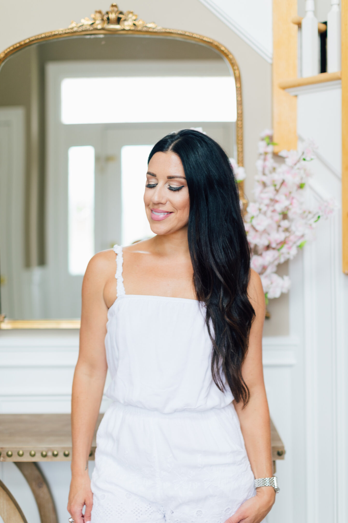 woman with long black hair and wearing white dress showing her Current Everyday Makeup Favorites