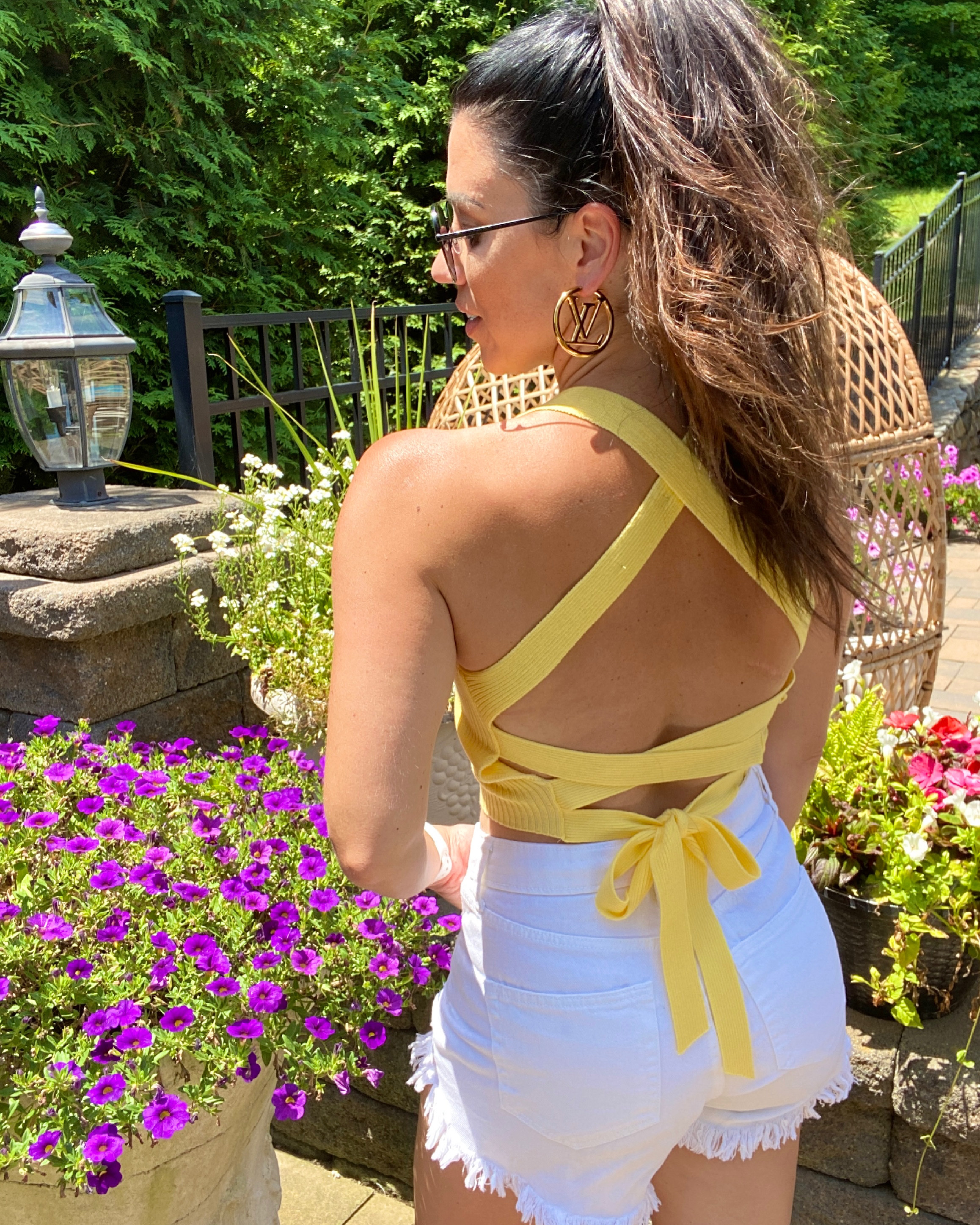 woman wearing yellow top and white shorts