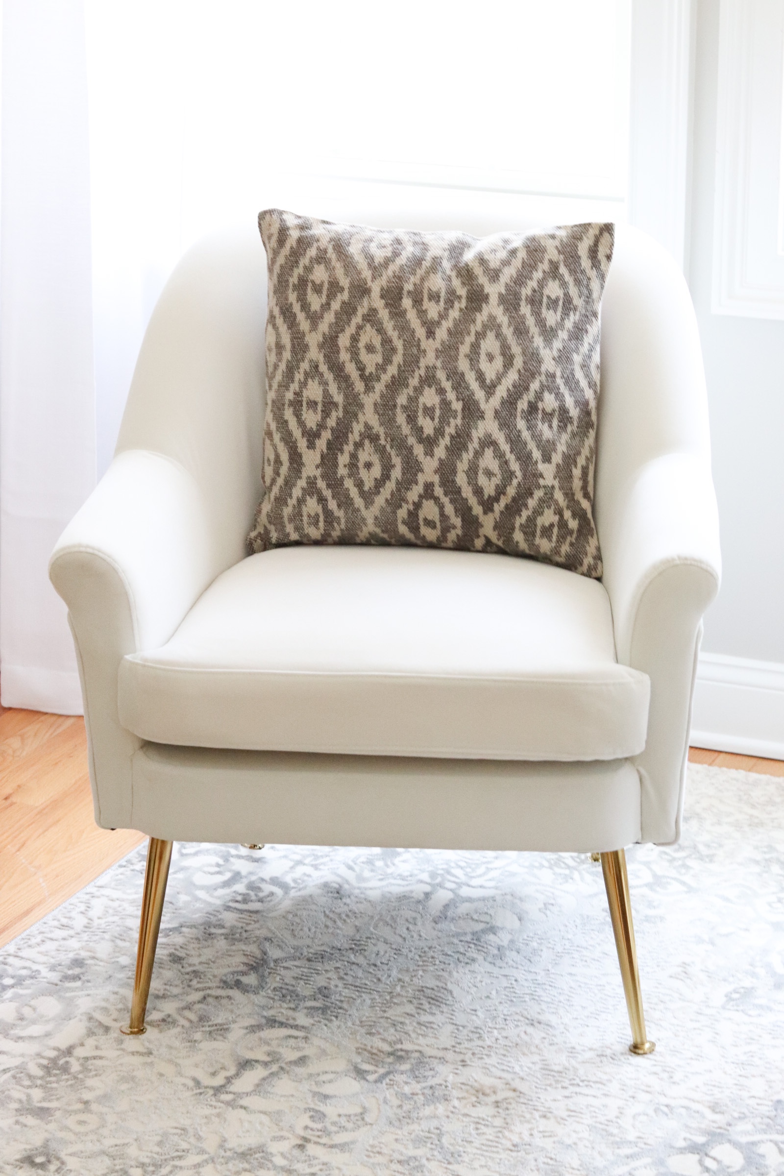 white chair and cushion on master bedroom sitting area